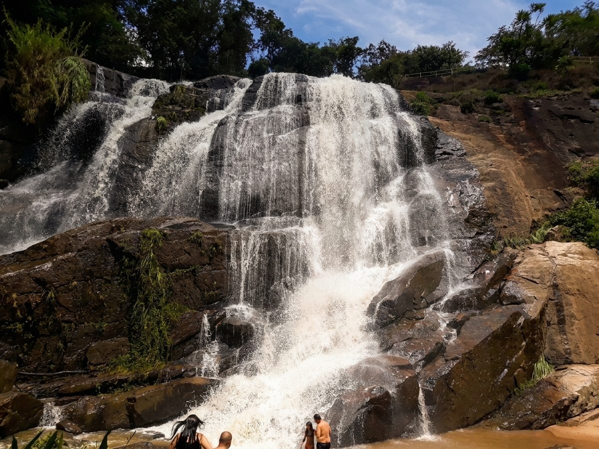 Cachoeira com quedas sobre as pedras e mata em volta