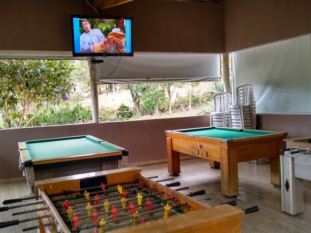 Salão de jogos com sinuca, pebolim e TV