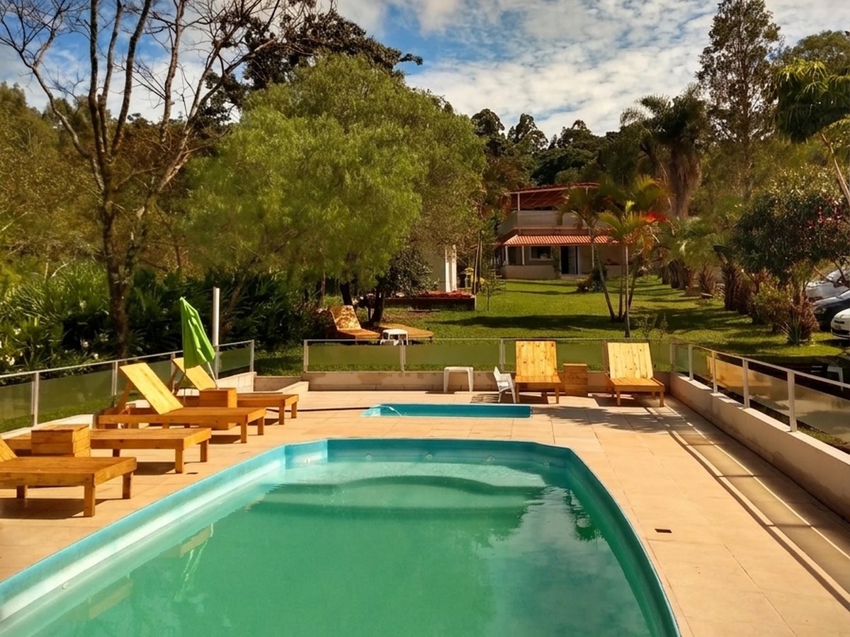 Piscina com deck, espreguiçadeiras e céu aberto